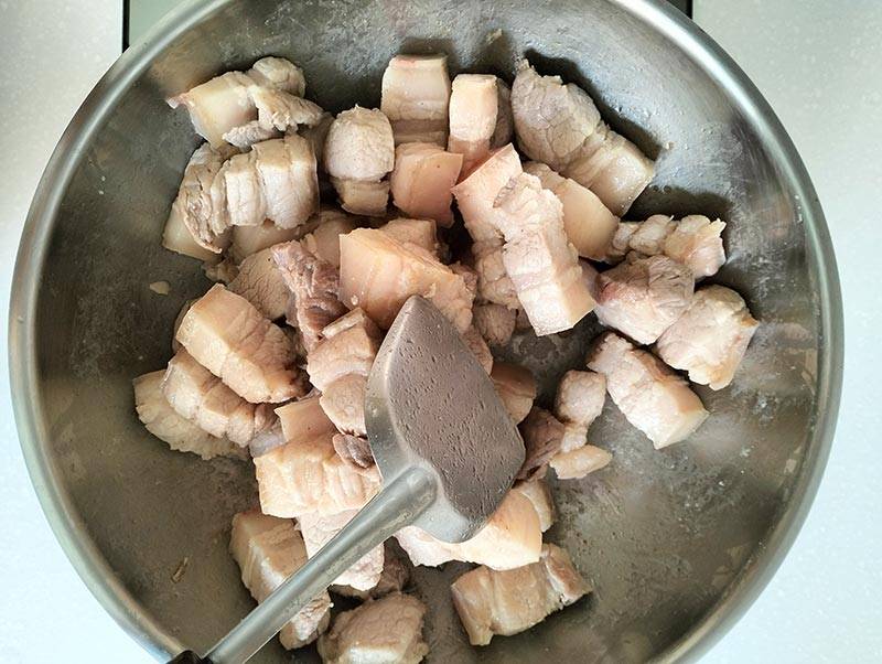 Stir fry pork belly in a skillet