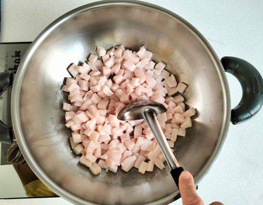 Stirring pork fat on a wok.