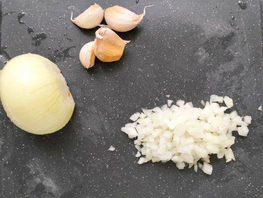 onion and garlic on cutting board