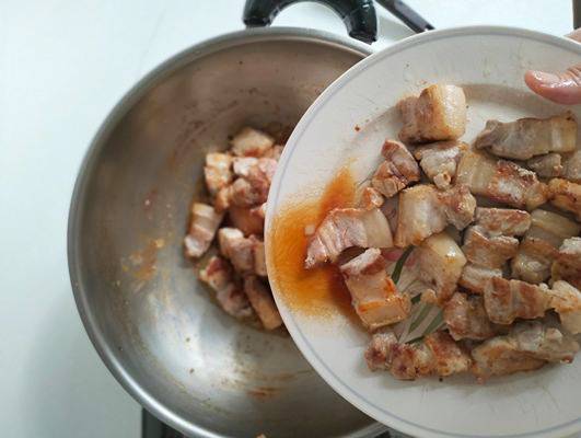 Adding pork belly back into the wok after deglazing. 