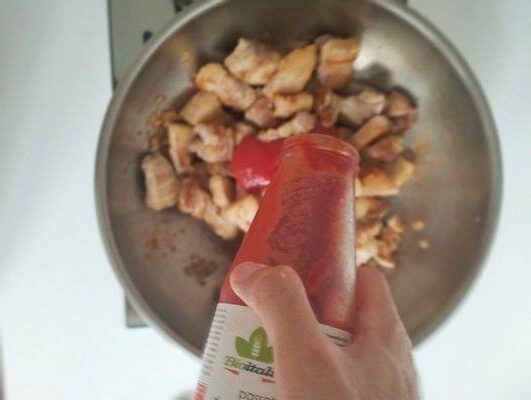 Adding passata sauce into the wok. Before adding, other ingredients, like sugar.