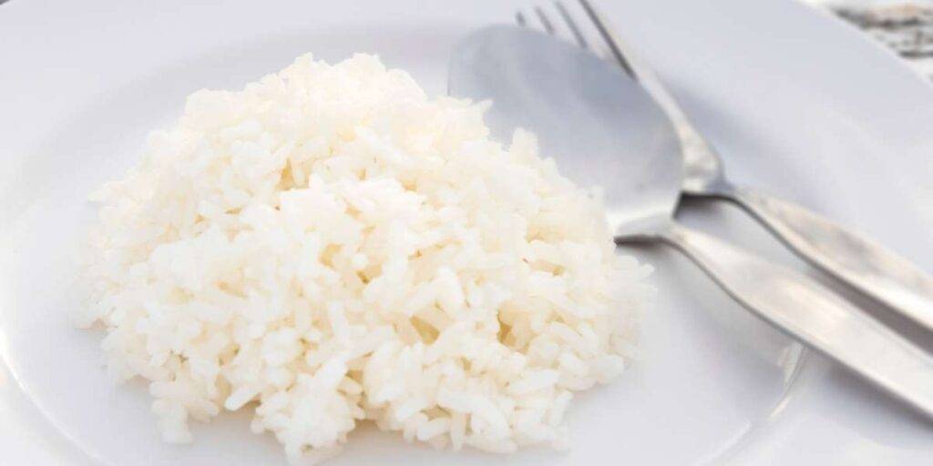 Rice on a plate. Spoon and fork next to it.