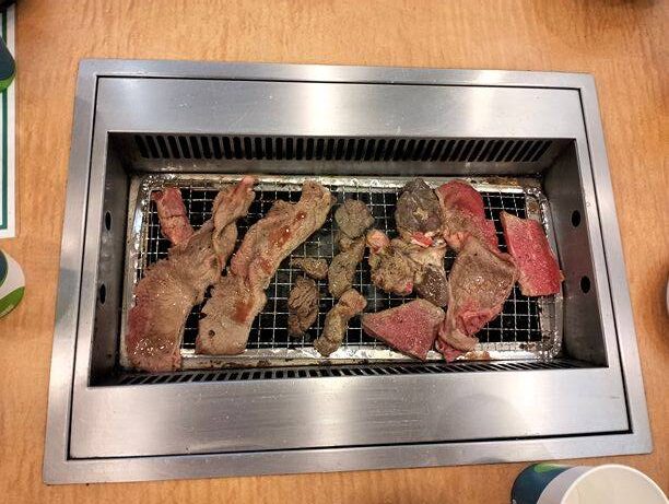 Grilling beef and pork at Yakiniku buffet restaurant.