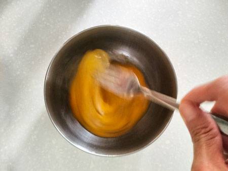 beating the eggs to combine egg white and egg yolk
