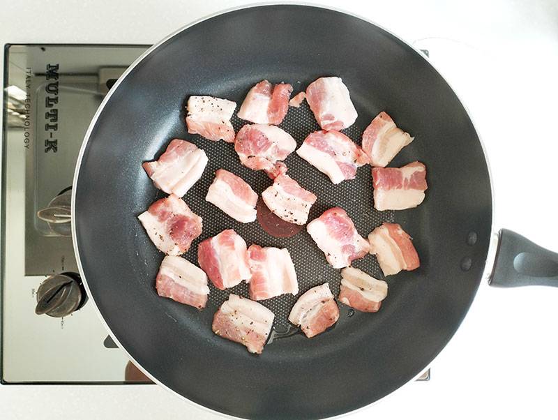 Cooking meat on non stick pan on stove top.