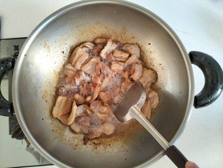 stir frying pork on wok