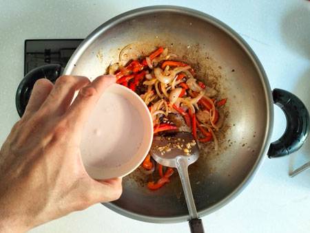 pour coconut milk into wok