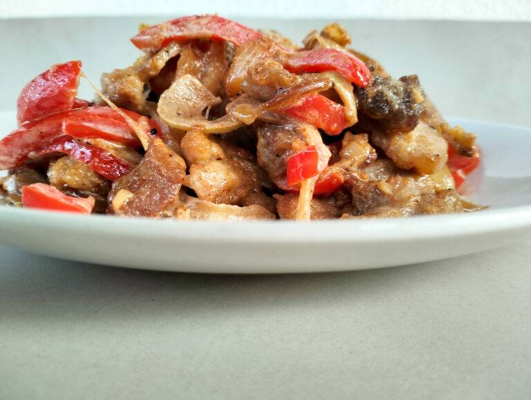 Pork coconut milk stir fry dish on a white plate placed on table.